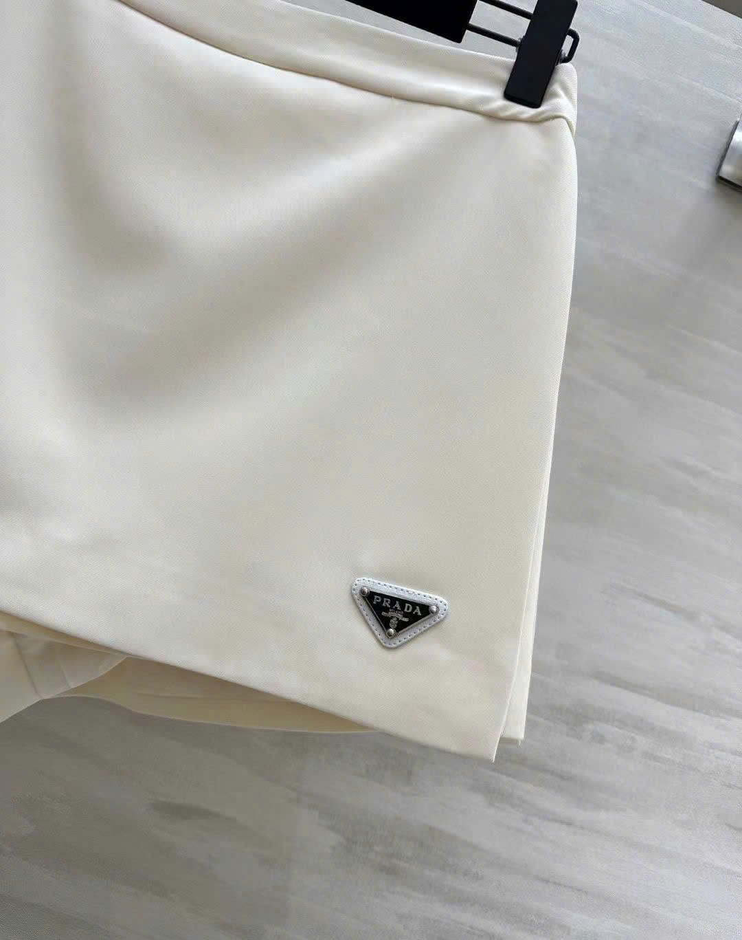 Chân váy vạt xéo kem và hồng Prada 10